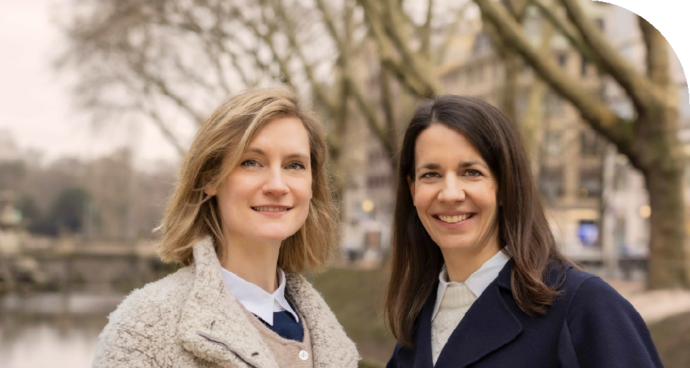 Frau Dr. Junghanns und Frau Dr. Siebeck Außenaufnahme in Düsseldorf an der Kö mit Bäumen und Gebäuden im hintergrund